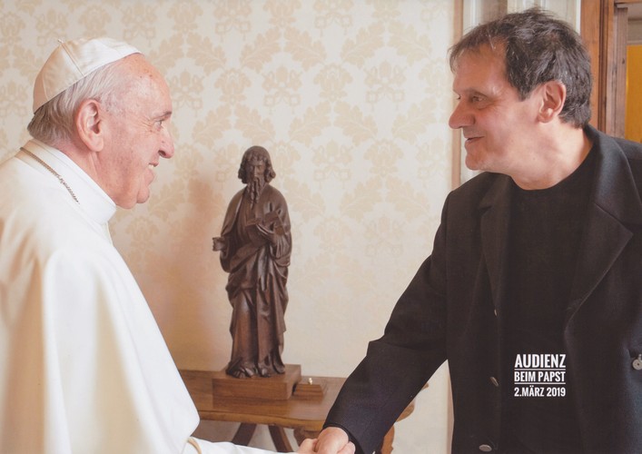 Photo of Mario Delfino and Pope Francis shaking hands.